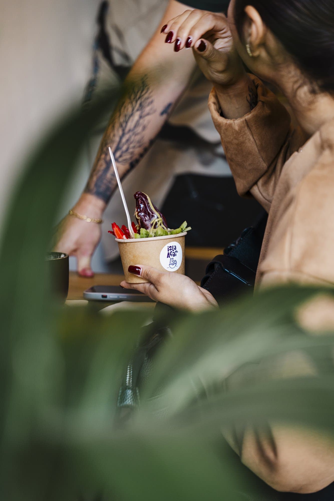 Clienta disfrutando de un açaí bowl de Isla Açaí en la terraza